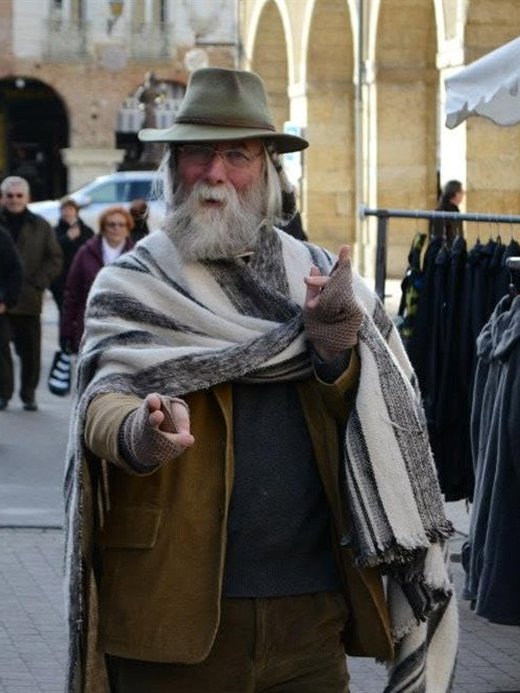 In a woven poncho at a market square in south-west France